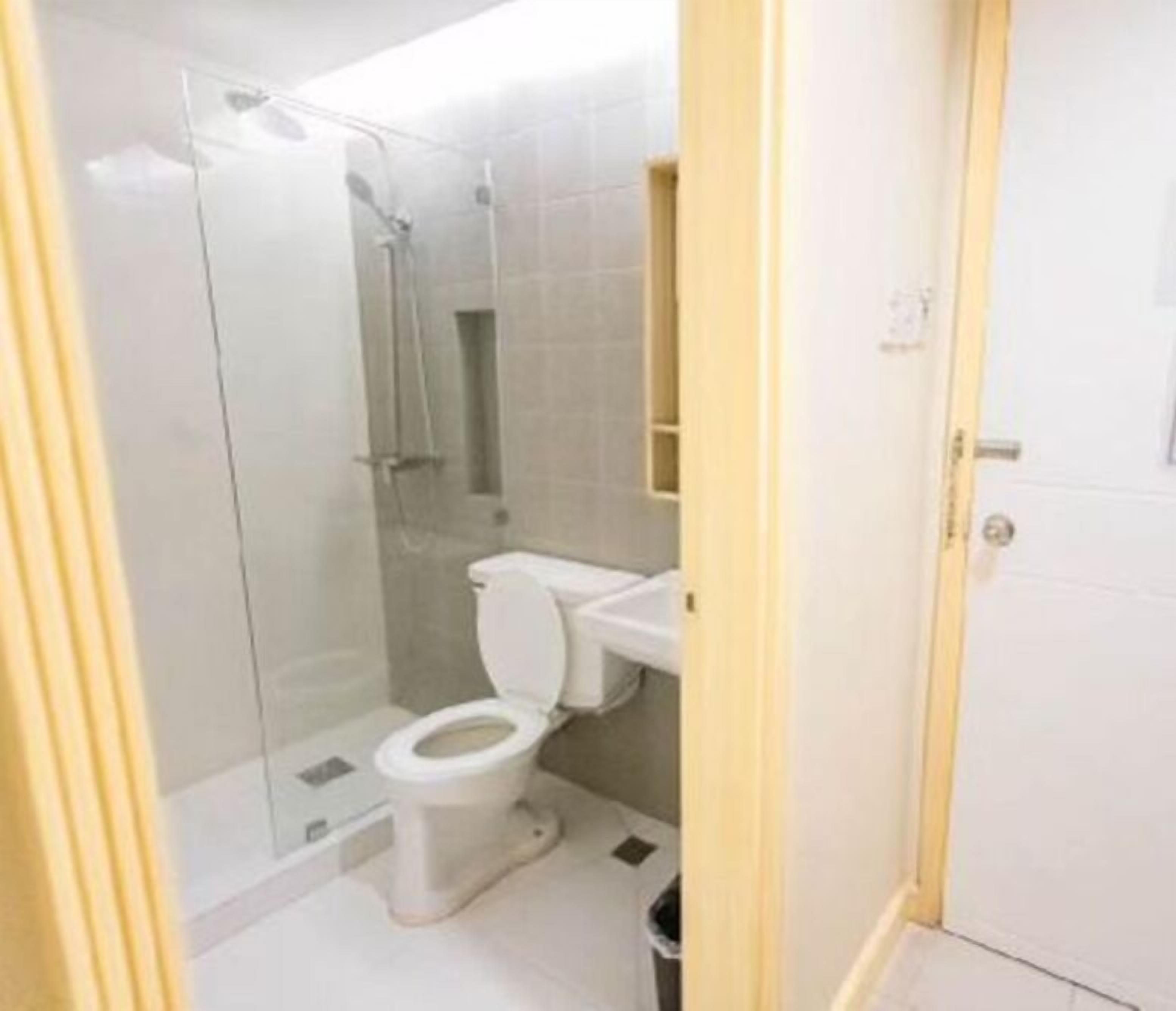 Et badeværelse med toilet, brusekabine og vask.