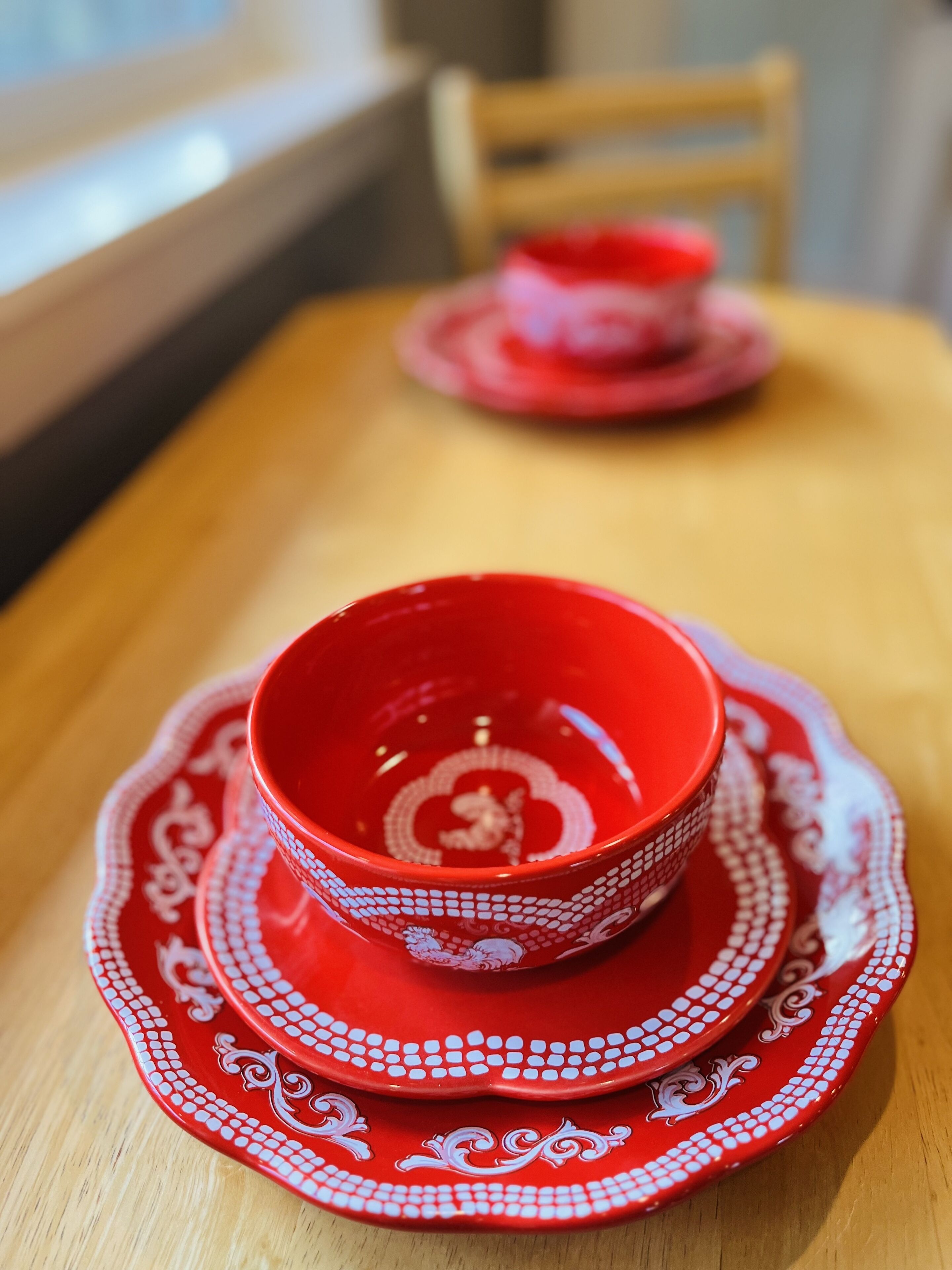 A dining table with a red and white patterned set.
