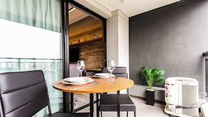 A modern dining area with a round table, black chairs, and a potted plant. - Trends Brooklin (São Paulo)