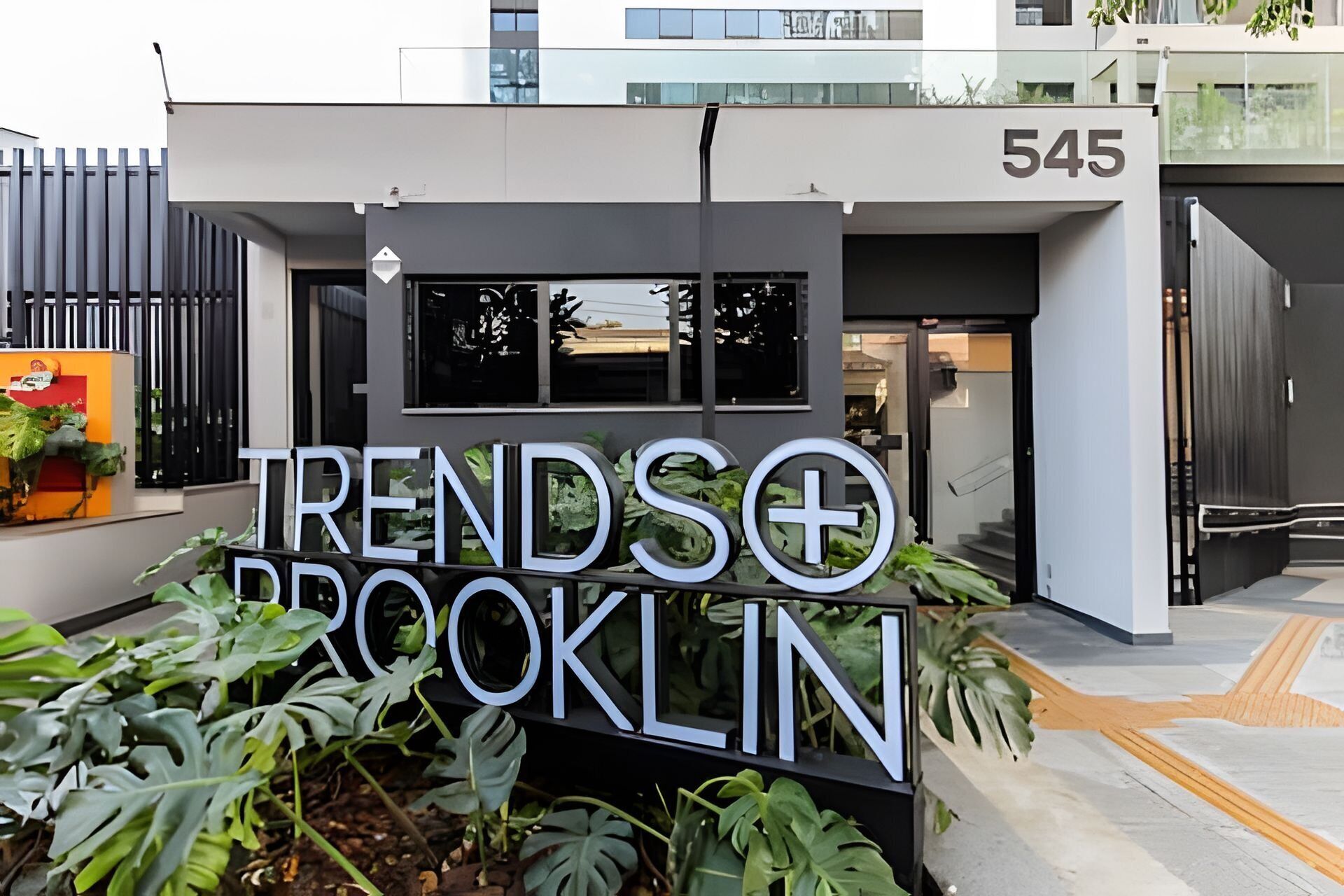Un bâtiment moderne sur lequel on peut lire l’inscription « Trends+Brooklyn » et le numéro 545.
