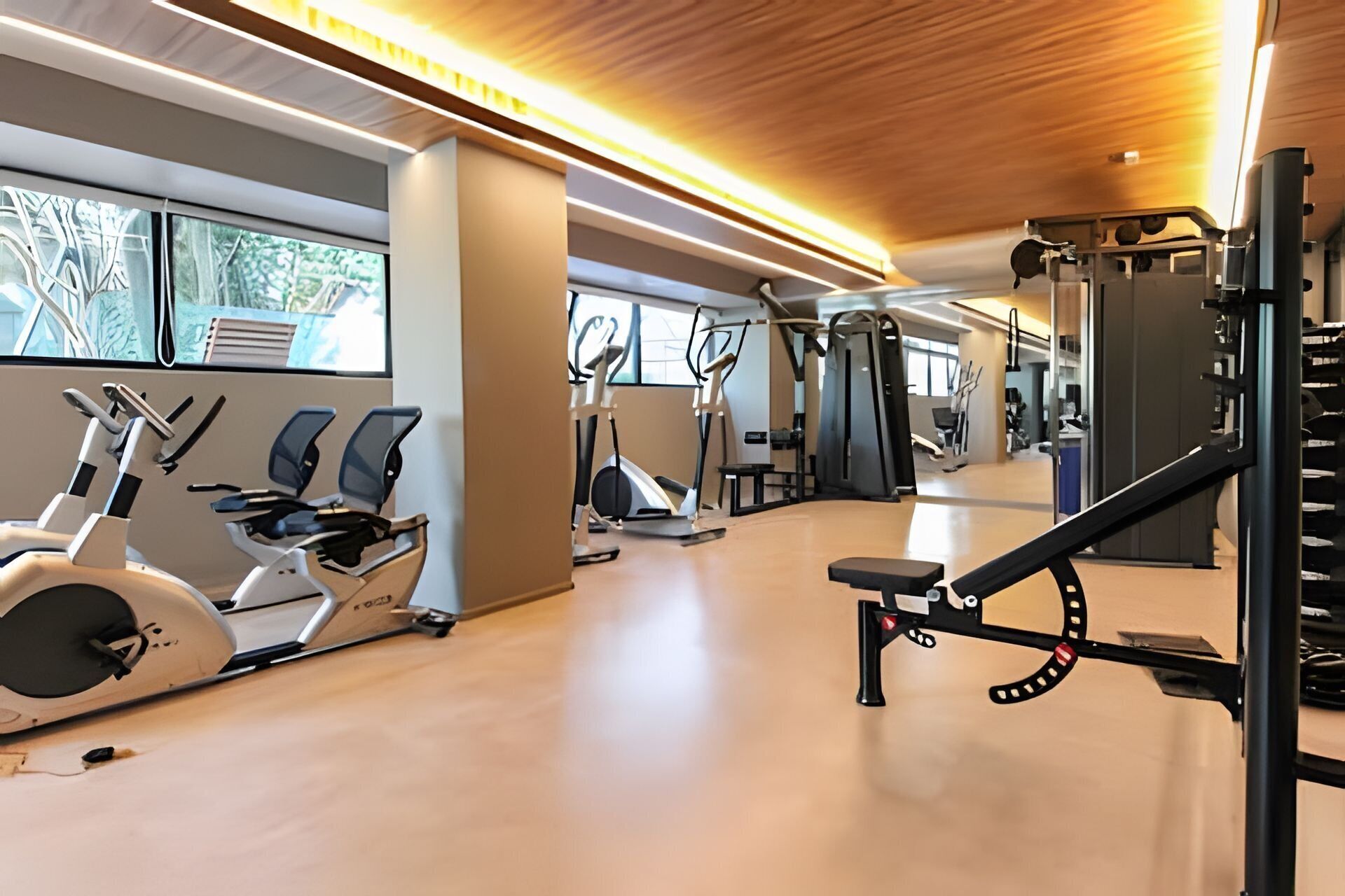 Et moderne fitnesscenter med løbebånd, vægte og en spejlvæg.