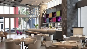 A modern restaurant with a bar area, large windows, and a variety of seating options. - Splash into Downtown Miami with tech-led smart stays & sunset drinks by the pool (Miami)