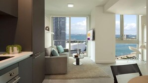 A modern living room with a sofa, a coffee table, and a view of the sea. - Splash into Downtown Miami with tech-led smart stays & sunset drinks by the pool (Miami)