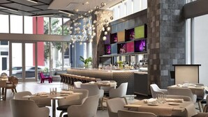 Un restaurante moderno con una zona de bar, amplios ventanales y diversas opciones de asientos.