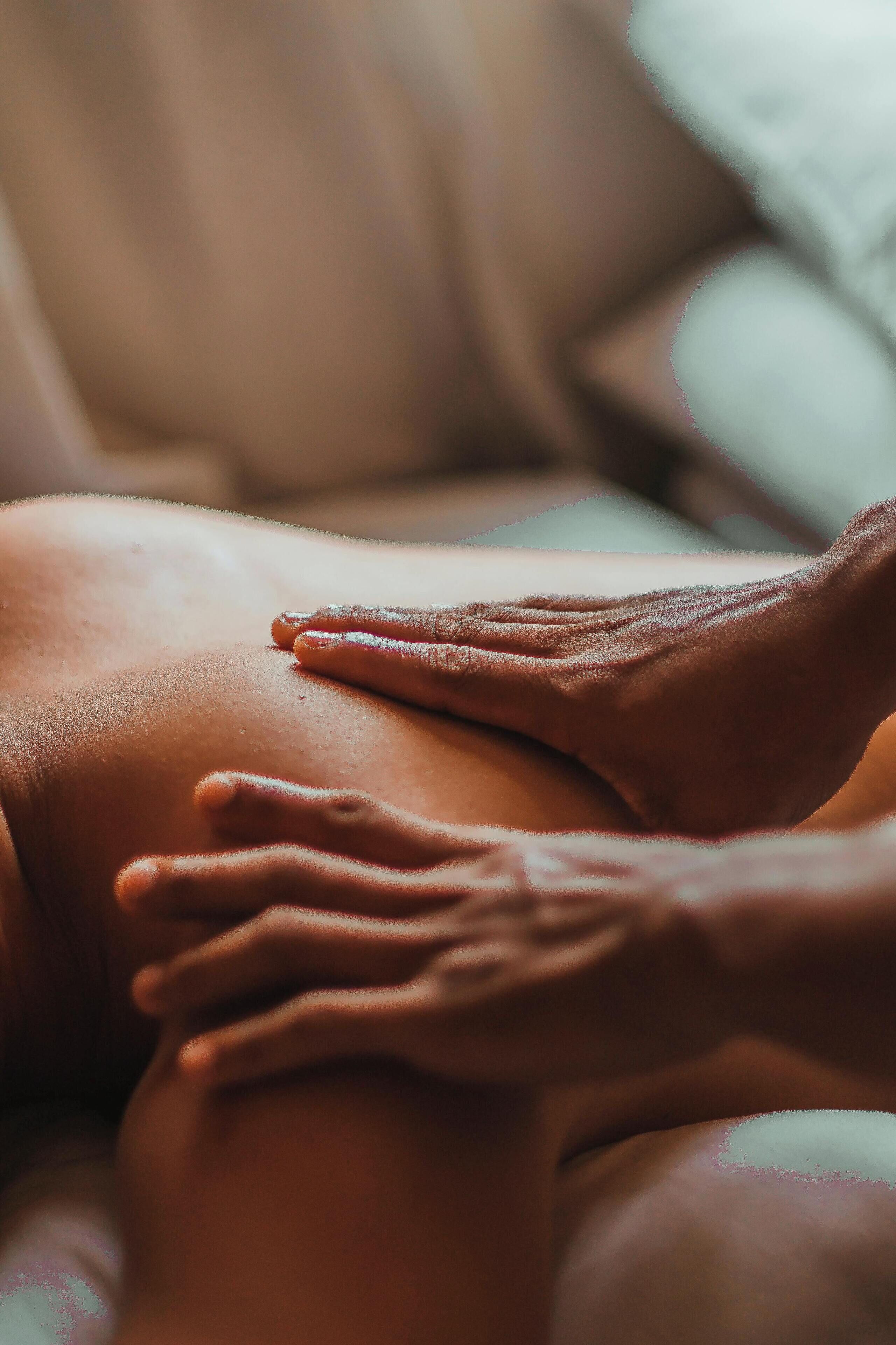 A close-up of hands on a person's back.