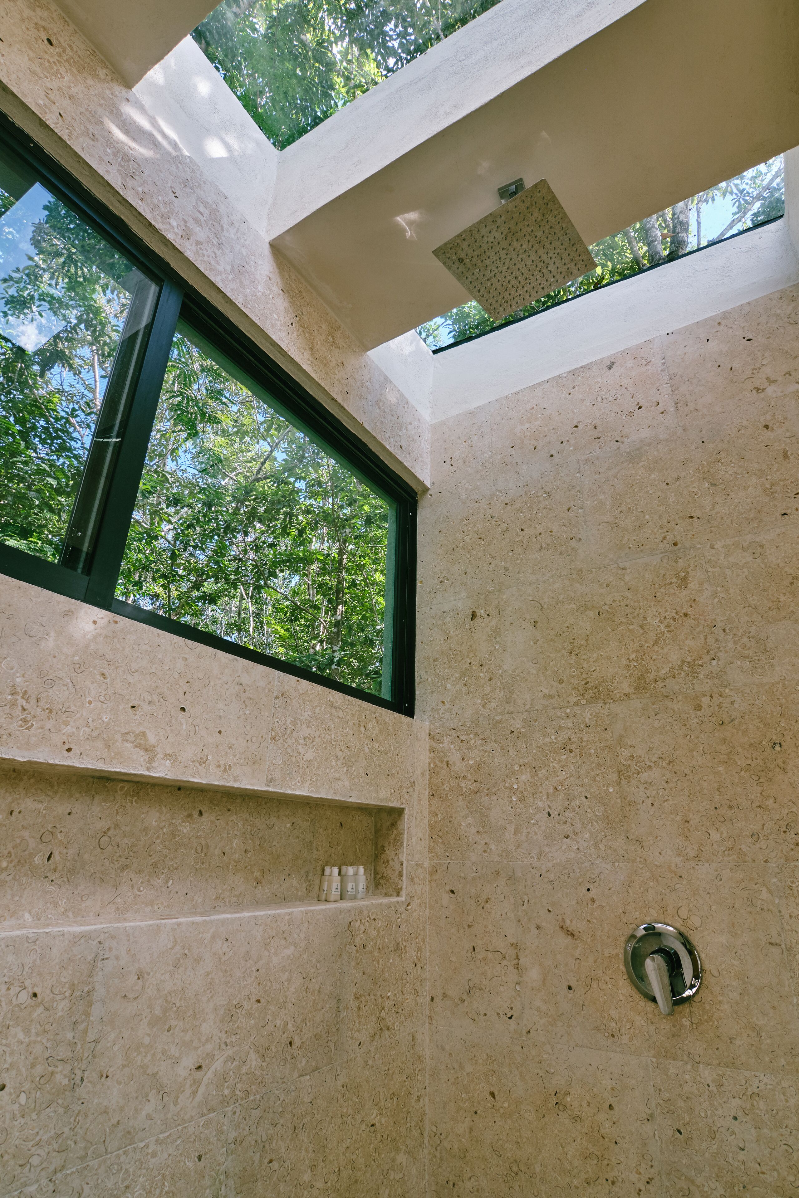 Une salle de bain moderne avec un puits de lumière, une douche et un lavabo.