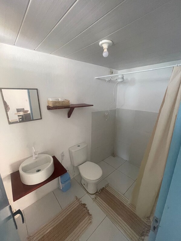 A bathroom with a sink, toilet, and shower.