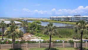 Un hôtel situé sur la côte, composé de plusieurs bâtiments, avec un plan d’eau et des palmiers.