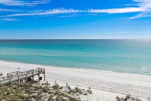 A beach with a wooden boardwalk leading to the shore. - Fabulous view of the Gulf and white sandy beach. One free beach chair set up dai (Destin)