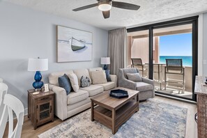 A living room with a sofa, armchairs, a coffee table, and a view of the ocean. - Beach front unit at Jetty East! One free beach chair set up daily. (Destin)