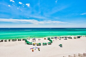 A beach with clear turquoise water and a sandy shore. - Beautiful, customized beach front unit. One beach chair set up daily. (Destin)