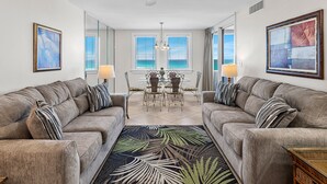 A living room with two sofas, a dining table, and chairs. - Spacious three-bedroom unit! One free beach chair set up daily. (Destin)