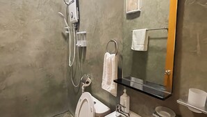 A modern bathroom with a toilet, sink, mirror, and shower. - Sunset Paradise Moaboal (Moalboal)