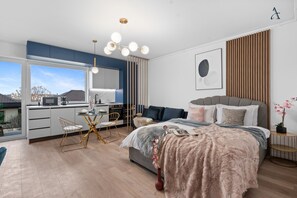 Un dormitorio moderno con una cama grande, un comedor y una cocina.