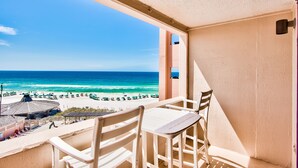Ein Balkon mit Blick auf Strand und Meer.