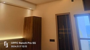 Une chambre moderne dotée d’un ventilateur de plafond, d’un éclairage encastré et d’une armoire en bois.