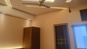 Habitació moderna amb ventilador de sostre, il·luminació empotrada i un armari de fusta.