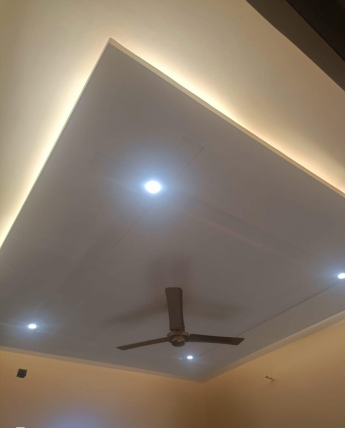 Una habitación con ventilador de techo, iluminación empotrada y una marca de fecha y hora visible.