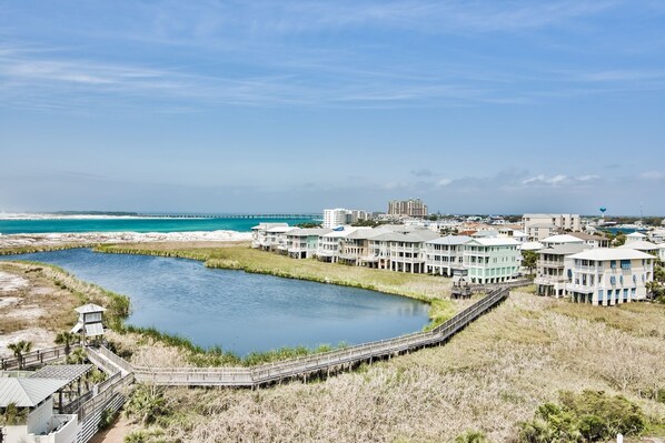 A coastal hotel with multiple buildings, a water body, and a boardwalk.