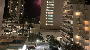 Un immeuble à plusieurs étages, doté de balcons et d’un espace de stationnement à l’avant.