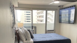 Une chambre à coucher moderne avec un lit, un canapé et un téléviseur.