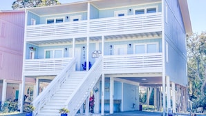 A multi-story building with a central staircase, balconies, and a sign indicating a Blue Chair establishment. - L👀K! NEW VRBO! Beach & Lake; Boat Ramp; Lake Powell! Rent both sides, sleeps 18 (Panama City Beach)