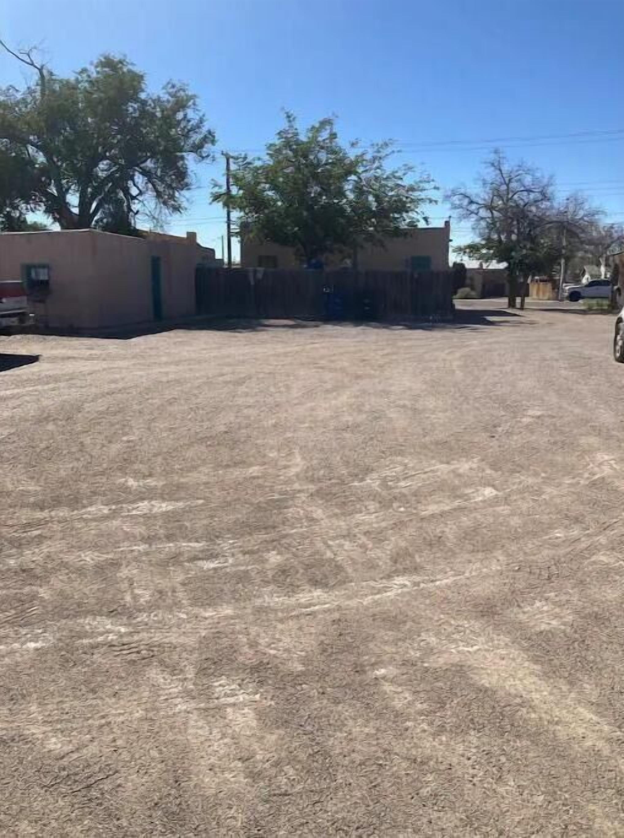 Un estacionamiento con un edificio al fondo.