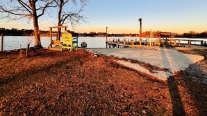 Un parco sul lago con un pontile di legno, panchine e una postazione di salvataggio.