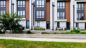 A row of modern townhouses with a uniform facade, featuring large windows and a flat roof. - Prime Nashville Getaway – Peaceful Area (Nashville)