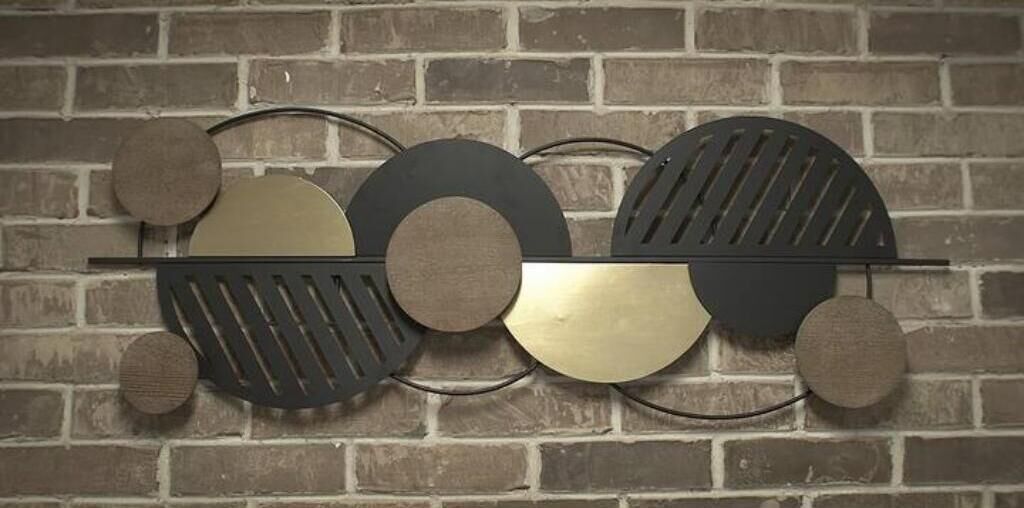 A wall-mounted abstract art piece with circular and semi-circular shapes in black, gold, and brown colors.