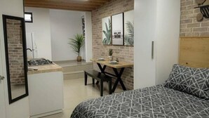 A compact room with a bed, a small desk, a chair, and a kitchenette. - Luxurious apartment near the consulate.

 (Juárez)