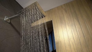 A shower with a modern design, a wooden wall, and a visible door frame. - Luxurious apartment near the consulate.

 (Juárez)