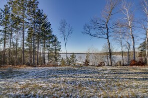 A snowy landscape with a bench, trees, and a body of water. - Hines Vacation Rental w/ Grill: Walk to Lake! (Hines)
