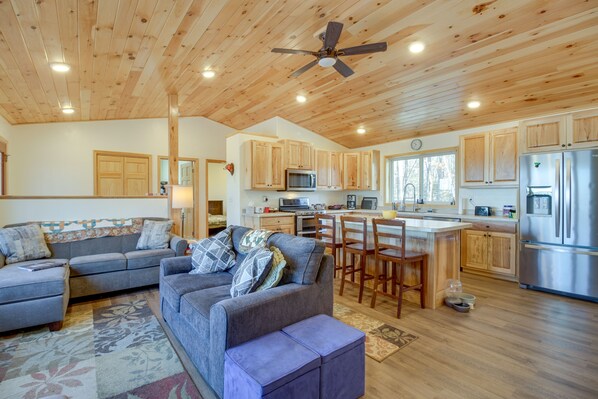 A spacious living room with a grey sofa, a coffee table, and a ceiling fan. - Hines Vacation Rental w/ Grill: Walk to Lake! (Hines)