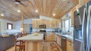 Une cuisine moderne avec des meubles en bois, des appareils électroménagers en acier inoxydable et un îlot central.