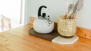 Een keuken met een moderne magnetron en een waterkoker op een houten tafel.