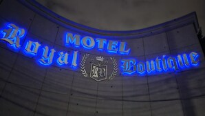 A curved sign with the text "Royal Boutique Motel" illuminated in blue. - ROYAL BOUTIQUE (Torreón)