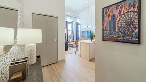 Een modern interieur met een keukenhoek, een eethoek en een zithoek met een groot schilderij.