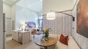Een moderne keuken met een eethoek, een ronde houten tafel en een bank met kussen.