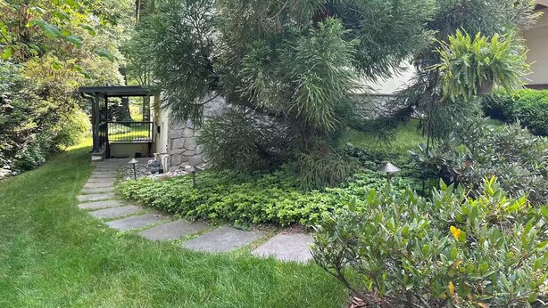 Ein Garten mit einem Kiesweg, der zu einem Gazebo führt.