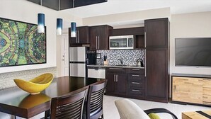 A modern kitchen with dark wood cabinets, a microwave, and a large flat-screen TV. - Luxury 2 BR Coral Vista Villa - Westin St John (Cruz Bay)