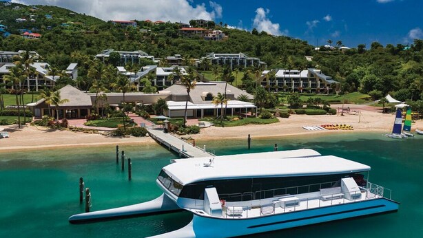 A coastal resort with a large white boat docked near the beach, surrounded by lush greenery and modern buildings. - Luxury 2 BR Coral Vista Villa - Westin St John (Cruz Bay)