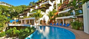 A resort with a swimming pool surrounded by lounge chairs and tropical plants. - Stunning HGTV Designer Villa - Panoramic Ocean Views - Private Hot Tub -Video (Puerto Vallarta)