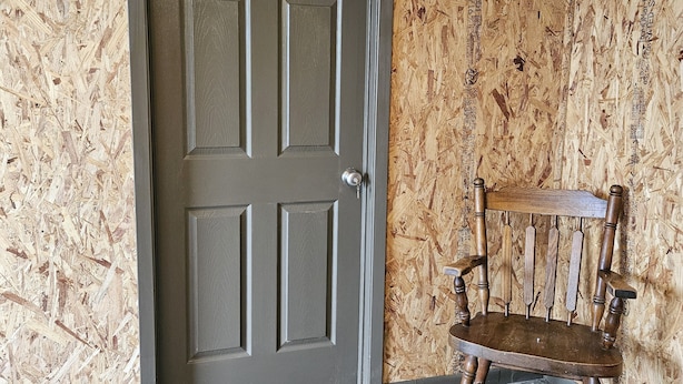 A room with a wooden door, a wooden chair, and a concrete floor. - Private 1 room studio near rhe lake (Burnet)