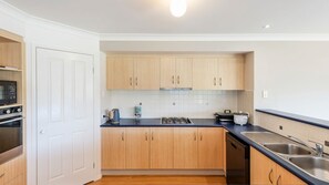 Una cocina moderna con armarios de madera, una estufa, un microondas y un lavavajillas.