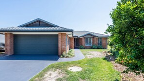 A residential property with a garage, a driveway, and a well-maintained lawn.