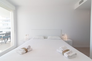 Une chambre d’hôtel avec un grand lit, deux tables de chevet, une fenêtre et une vue sur l’extérieur.