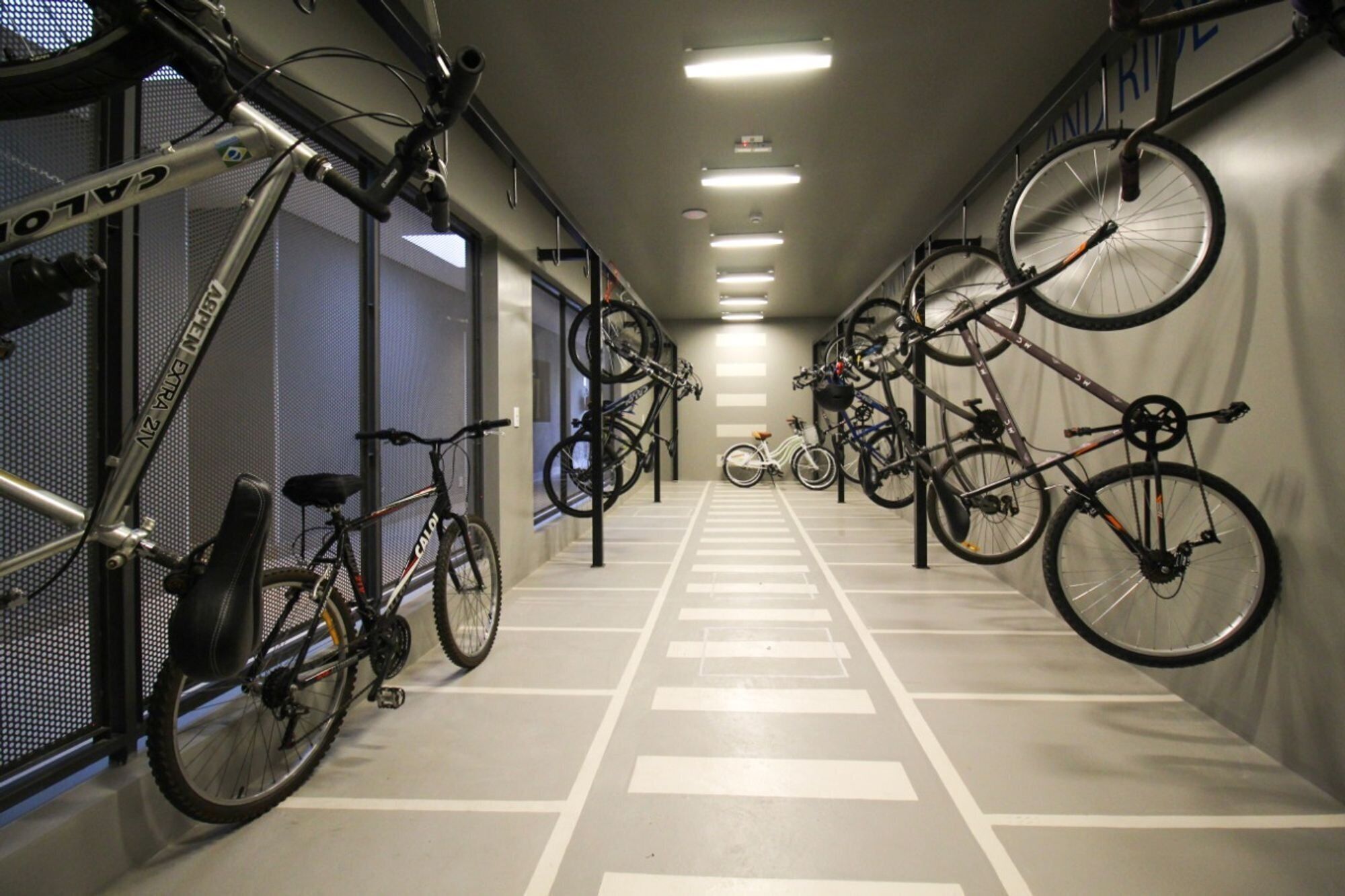 Ett område avsett för cykelförvaring, där ett flertal cyklar är uppställda längs väggarna och på cykelställ.