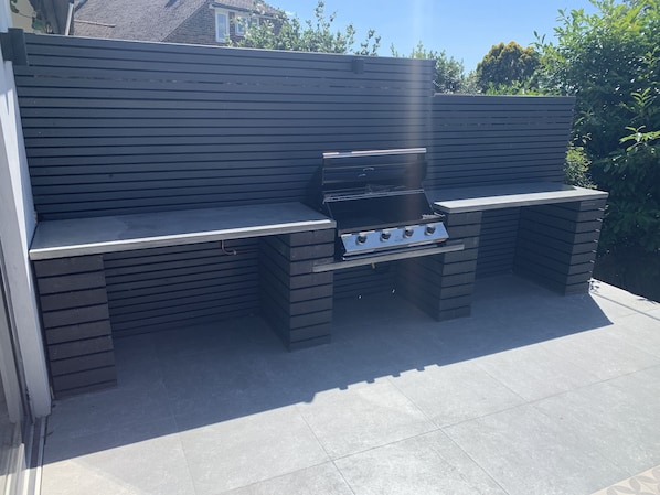 Enjoy al fresco dining at this outdoor barbecue area with a grill and comfortable seating.