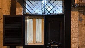 Una puerta negra con un panel de vidrio y una ventana encima.
